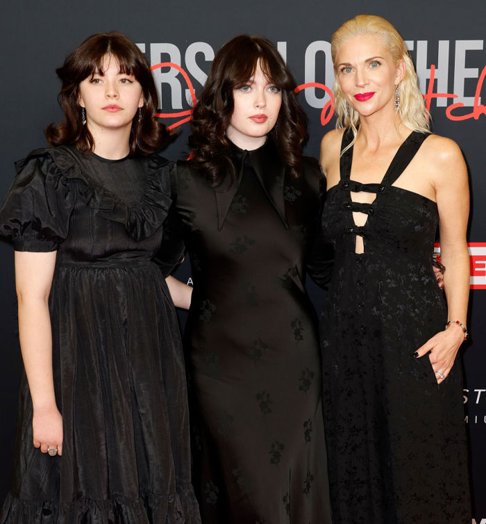 Three women in elegant black dresses at a formal event, featuring Jordyn Blum.