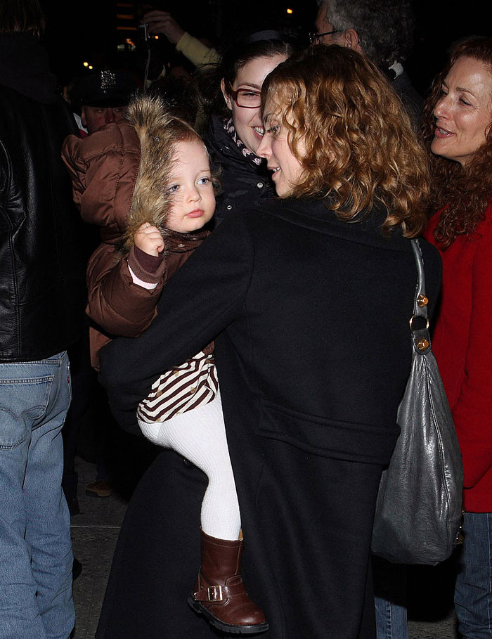 Jordyn Blum holding a child while smiling at an outdoor event.