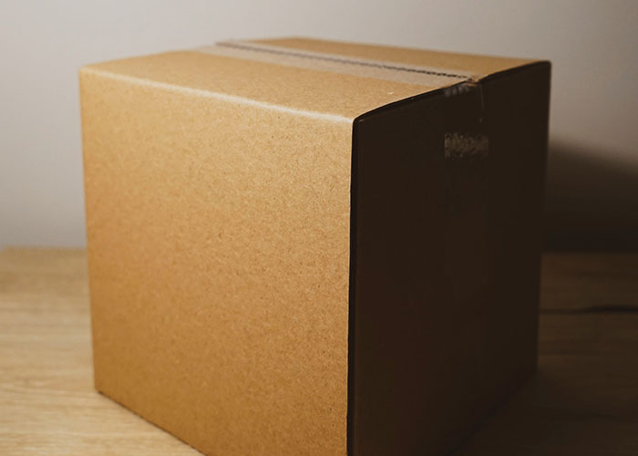 Cardboard box on a wooden table, symbolizing unexpected courtroom evidence in strange human behavior cases.