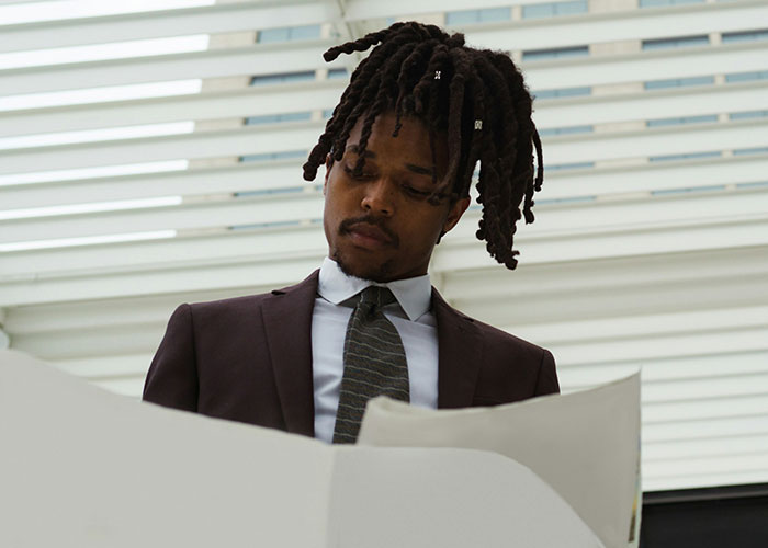 Man in courtroom setting analyzing documents, showcasing strange human behavior.