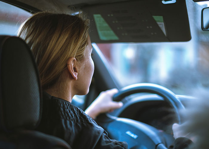 "Person driving a car, focused on the road, highlighting human behavior."