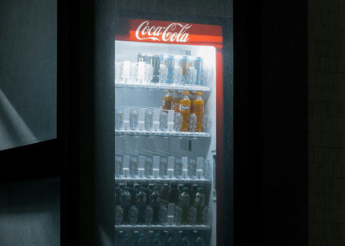 Vending machine glowing in the dark, filled with drinks like Coca-Cola and Fanta, creating an eerie nighttime scene.