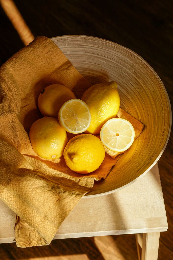 Bowl of fresh lemons on a wooden table with a yellow cloth, highlighting new facts from a learning community.