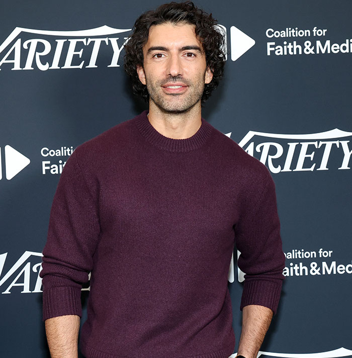 "Person in a maroon sweater at Variety event backdrop related to Justin Baldoni lawsuit.