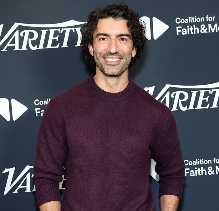 Justin Baldoni at Variety event, wearing a purple sweater, discussing scene controversy.