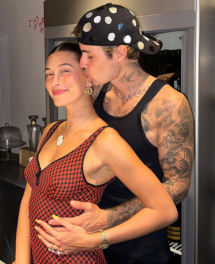 Hailey Bieber with Justin, embracing warmly in casual attire in a kitchen setting.