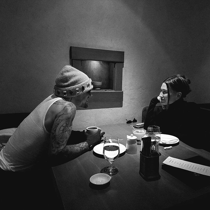 Hailey Bieber shares a candid dining moment with Justin, engaging in conversation.