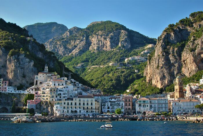 Scenic coastal village with colorful buildings in the Tuscany region of Italy, nestled between cliffs and the sea.