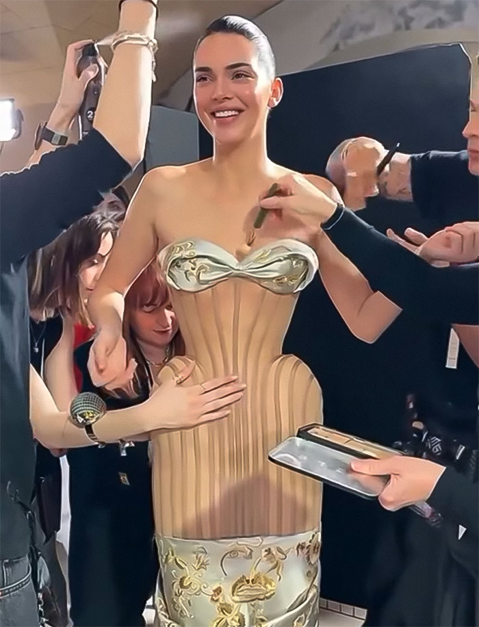 Kendall Jenner during Paris Fashion Week fitting, wearing an attention-grabbing dress, surrounded by stylists adjusting her outfit.