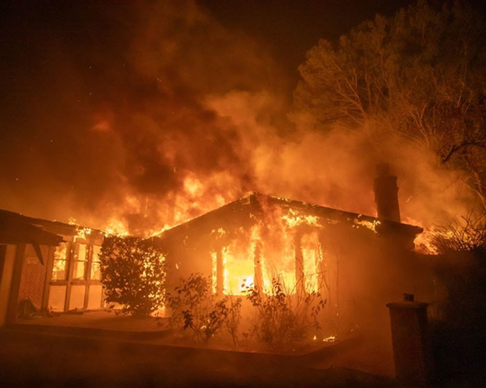 Burning house engulfed in flames illustrating Los Angeles wildfires tragedy.