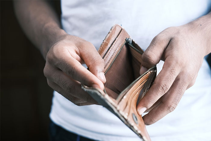 Person holding an open, empty wallet, reflecting wise observations on financial awareness.