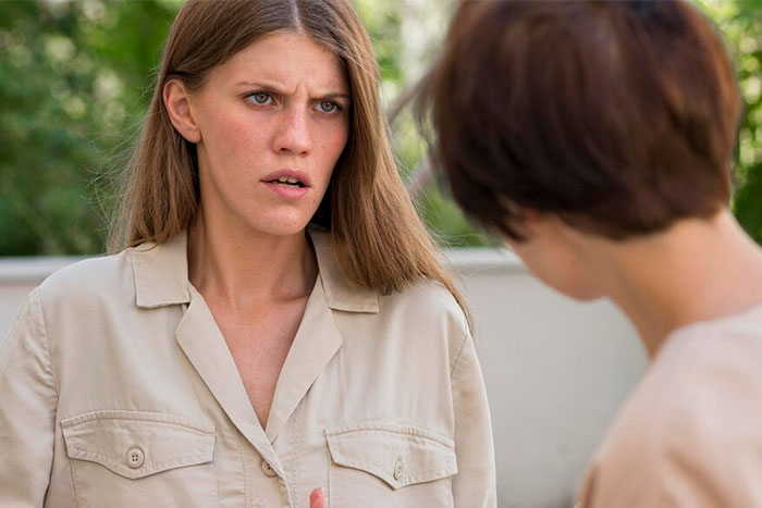 Two people engaged in a serious conversation, illustrating shared wise observations in a casual outdoor setting.