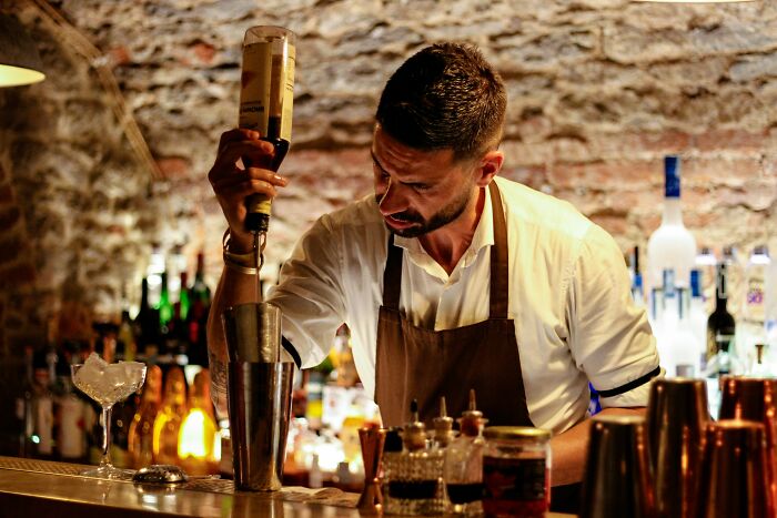 Bartender in a rustic bar mixing a drink, illustrating career red flags in hospitality jobs.