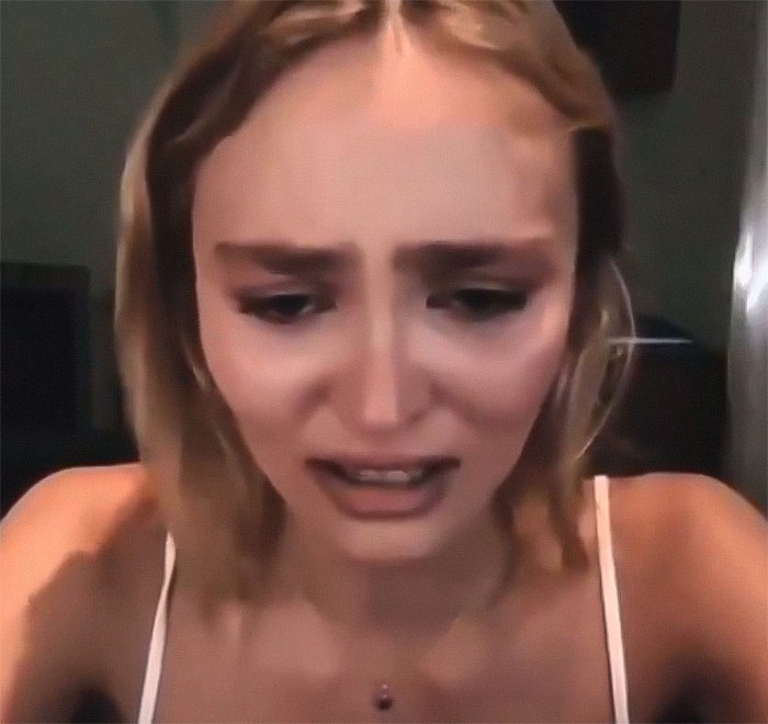 Young woman in a dimly lit room, appearing distressed, wearing a white top, related to Nosferatu audition.