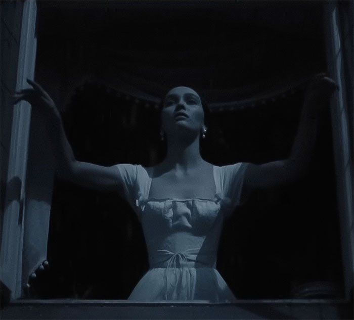 Image of an actress in a vintage dress, arms outstretched, in a dark, dramatic setting related to Nosferatu audition.