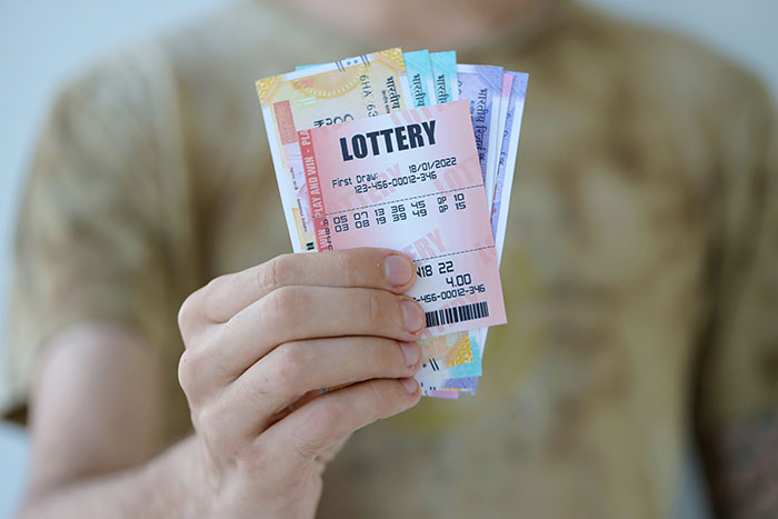 Person holding lottery tickets, illustrating the concept of winning lottery in a gifting context.