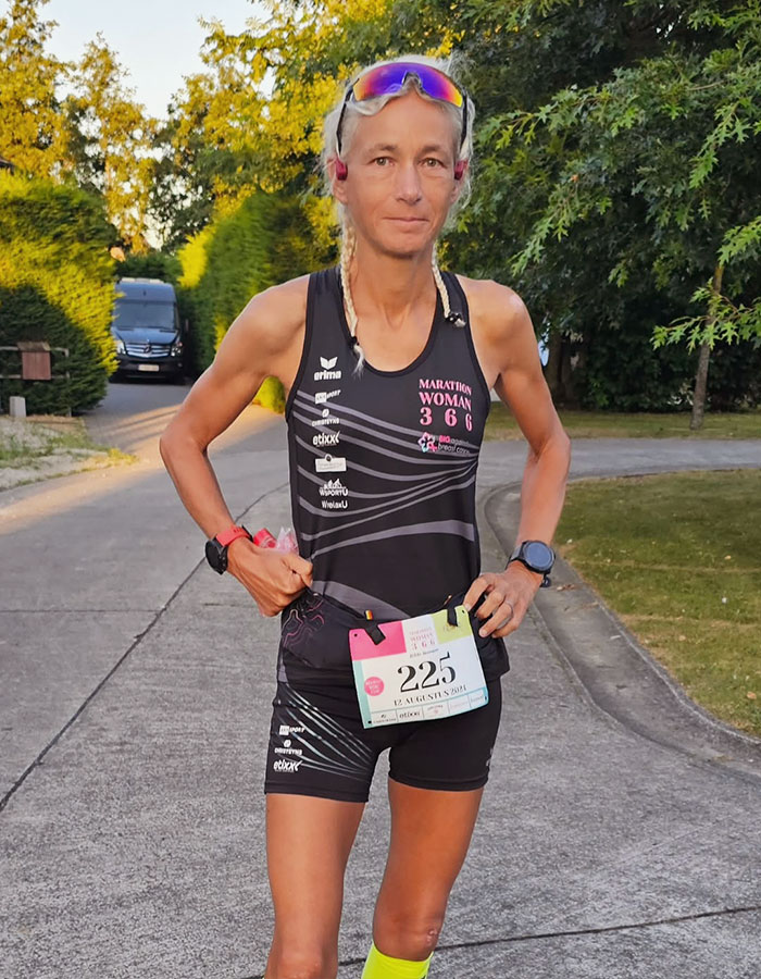 55-year-old woman sets world record by running 366 marathons in a year, wearing a race bib and gear.