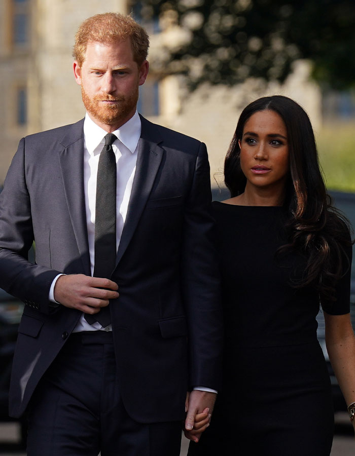 Royal couple walking outside, related to Meghan Markle's alleged behavior.