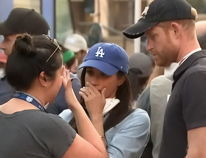 Prince Harry and Meghan Markle console someone wearing a LA hat during a visit to LA fire victims.