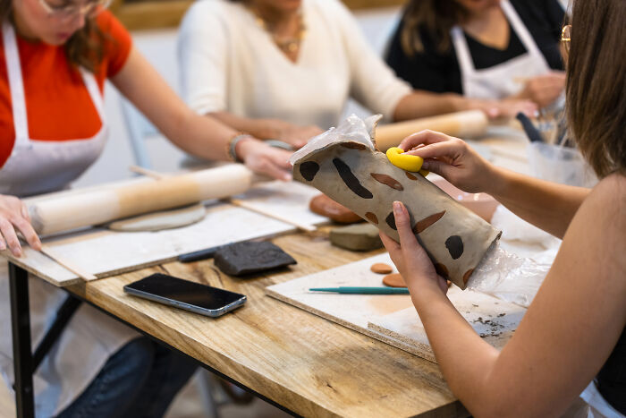 Friends crafting together around a table with rolling pins.