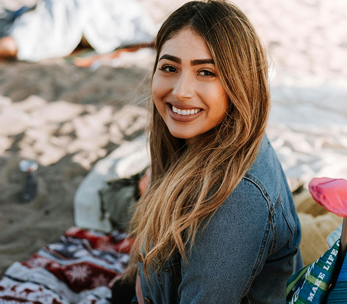 Smiling woman at the beach, embodying touching moments of kindness shared by people.