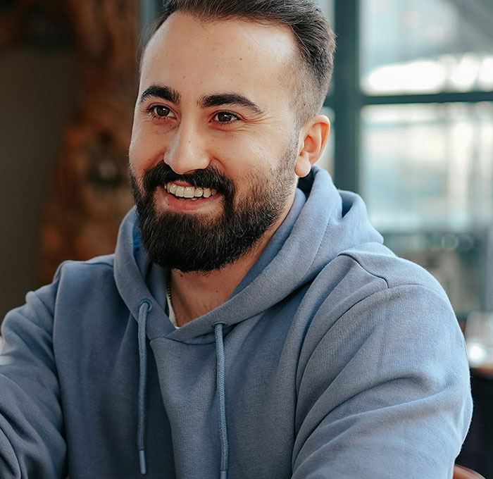 A smiling man in a blue hoodie, representing a touching moment shared by people.