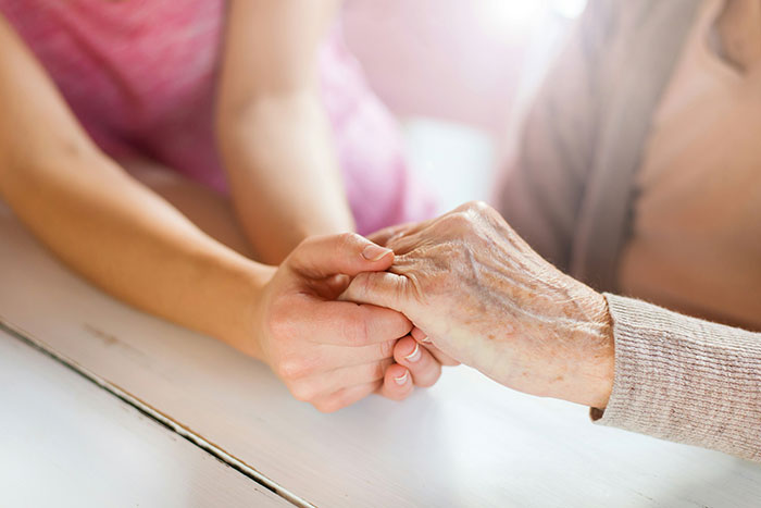 Two people holding hands, conveying a touching moment of connection and empathy.