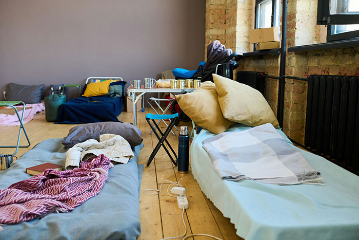 Makeshift sleeping area with pillows and blankets on the floor, reflecting a cozy and personal setting.