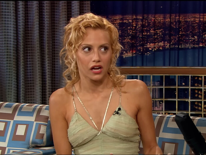 Blonde woman in a green dress on a talk show set, discussing impactful celebrity deaths.