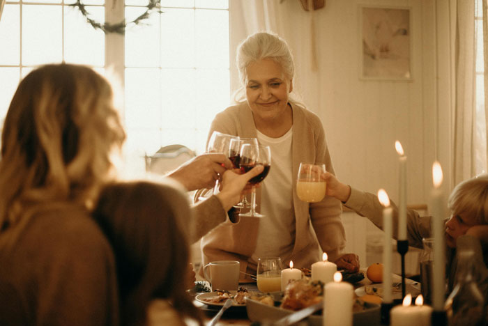 Family celebrating together, with a mother wearing an heirloom ring, enjoying a warm dinner gathering.