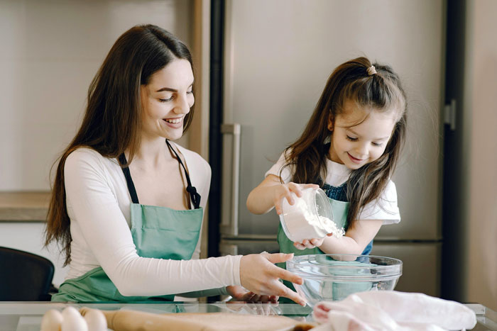 Mother and daughter baking together in a kitchen, emphasizing family connection.