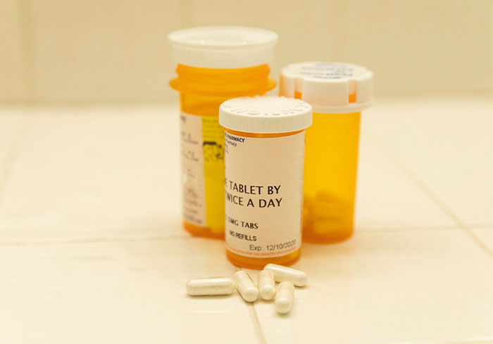 Prescription pill bottles and tablets, representing typical US healthcare practices.