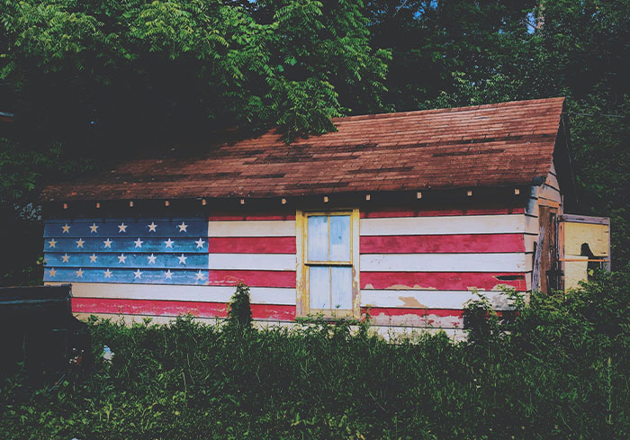 Small shack painted with the American flag, symbolizing things normal to US citizens but unusual to Europeans.