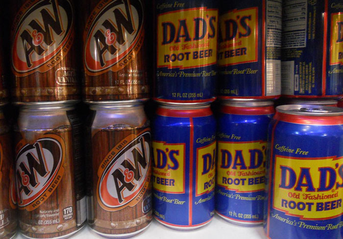 Cans of A&W and Dad's Root Beer, common in the US but less familiar in Europe, displayed on a shelf.