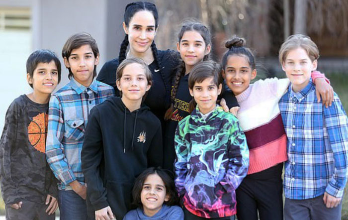 Octomom Nadya Suleman smiling with her octuplets, posing outdoors.