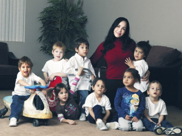 Nadya Suleman with her octuplets, sitting together in a living room setting.