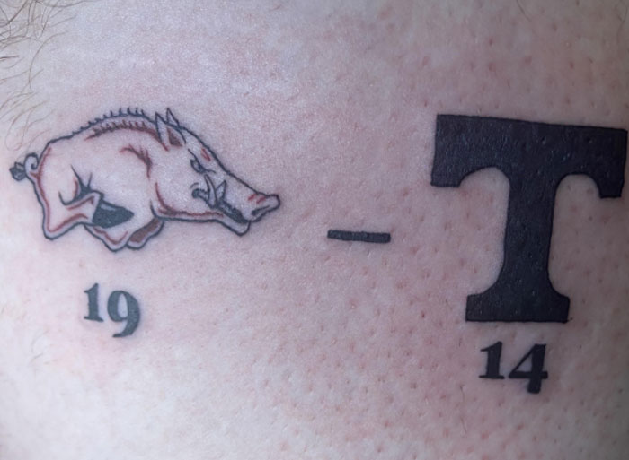 Tattoo of a boar with numbers 19 and 14, highlighting behaviors of those who peaked in high school.