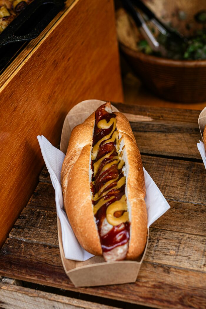 Hot dog with mustard and ketchup on a wooden surface; related to people who won lifetime supply stories.