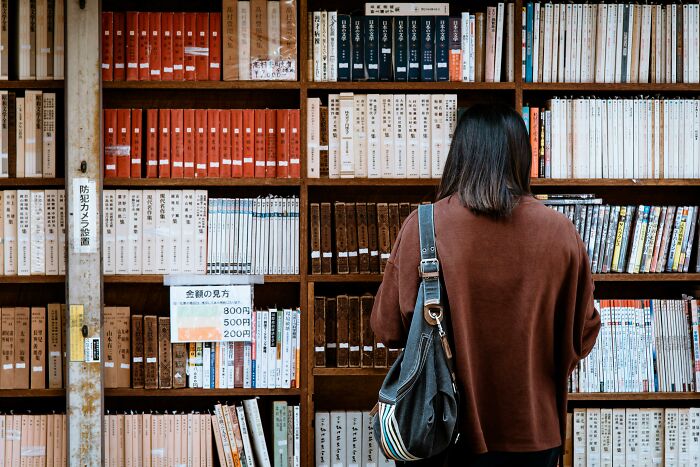 Person browsing books in a library.