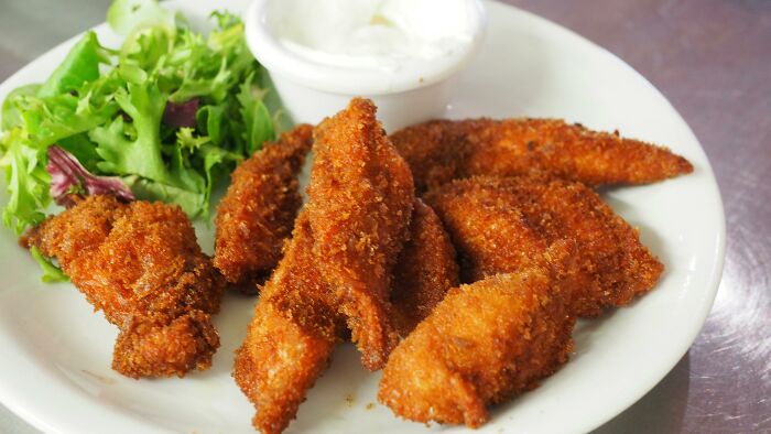 Plate of breaded fried chicken with greens, representing things that may lose appeal for older adults.