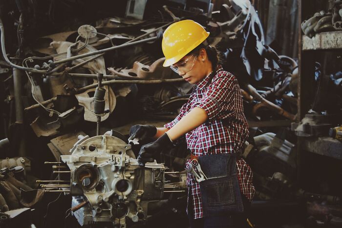 Person in a hard hat and gloves working on machinery, representing activities losing appeal for older adults.