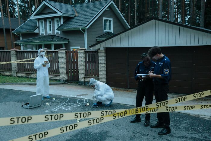 Forensic team investigates crime scene outside house, illustrating displays of genius in criminal investigations.