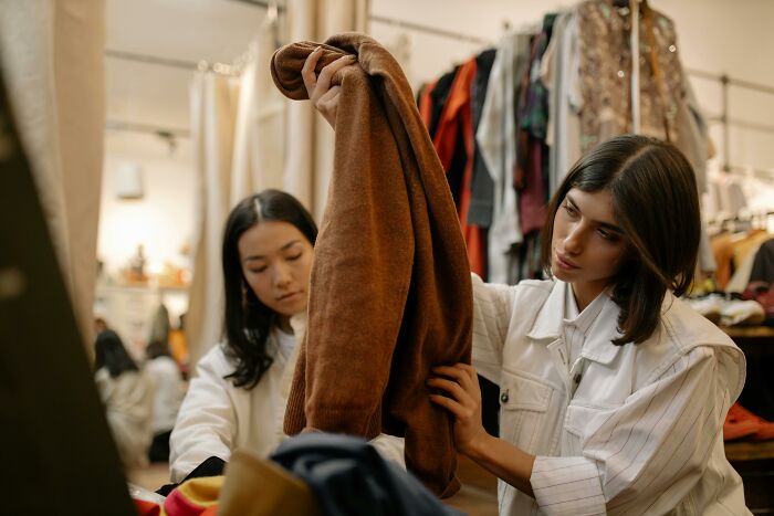 Women inspecting clothes in a store.