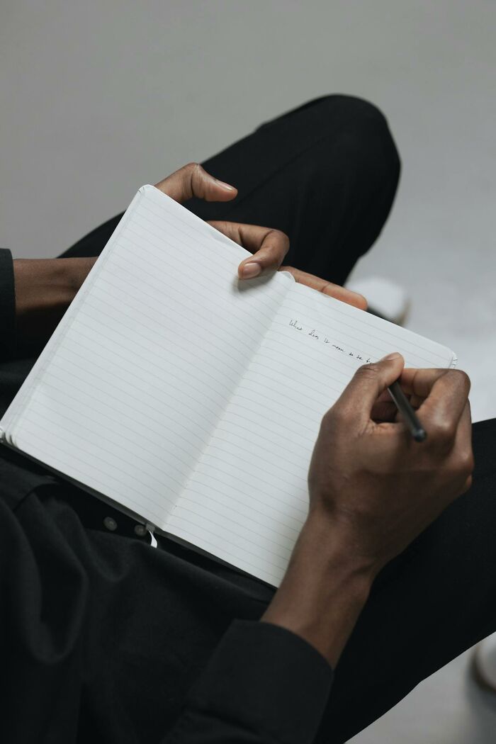 Man writing in a notebook, illustrating things men do that can turn women on.