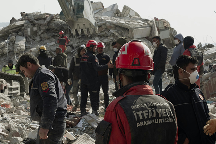 Rescue workers examining earthquake rubble.