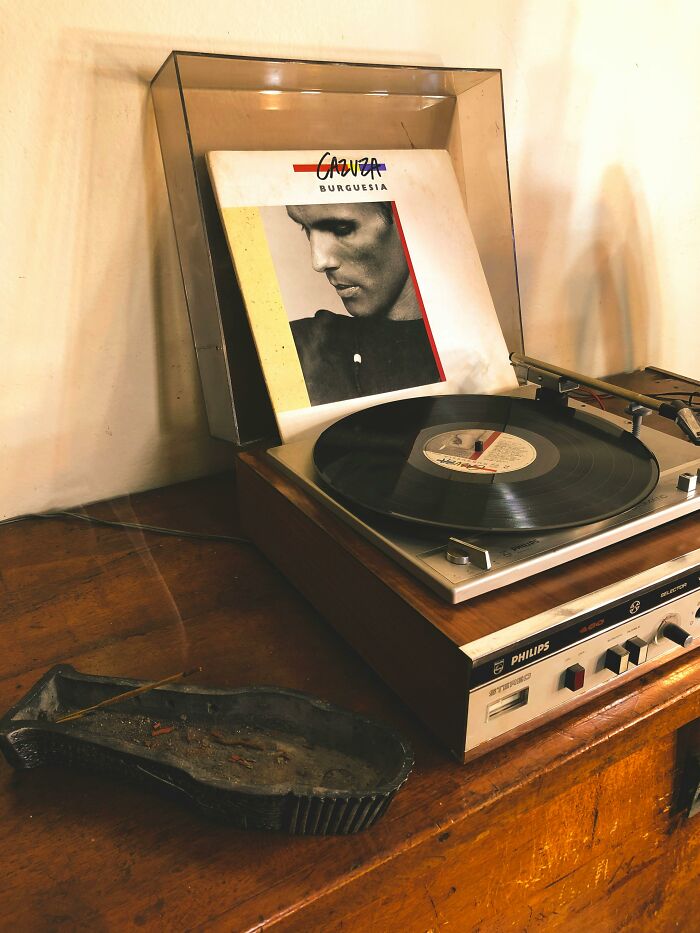 Vintage record player with vinyl album cover, illustrating nostalgia and simplicity in music appreciation.