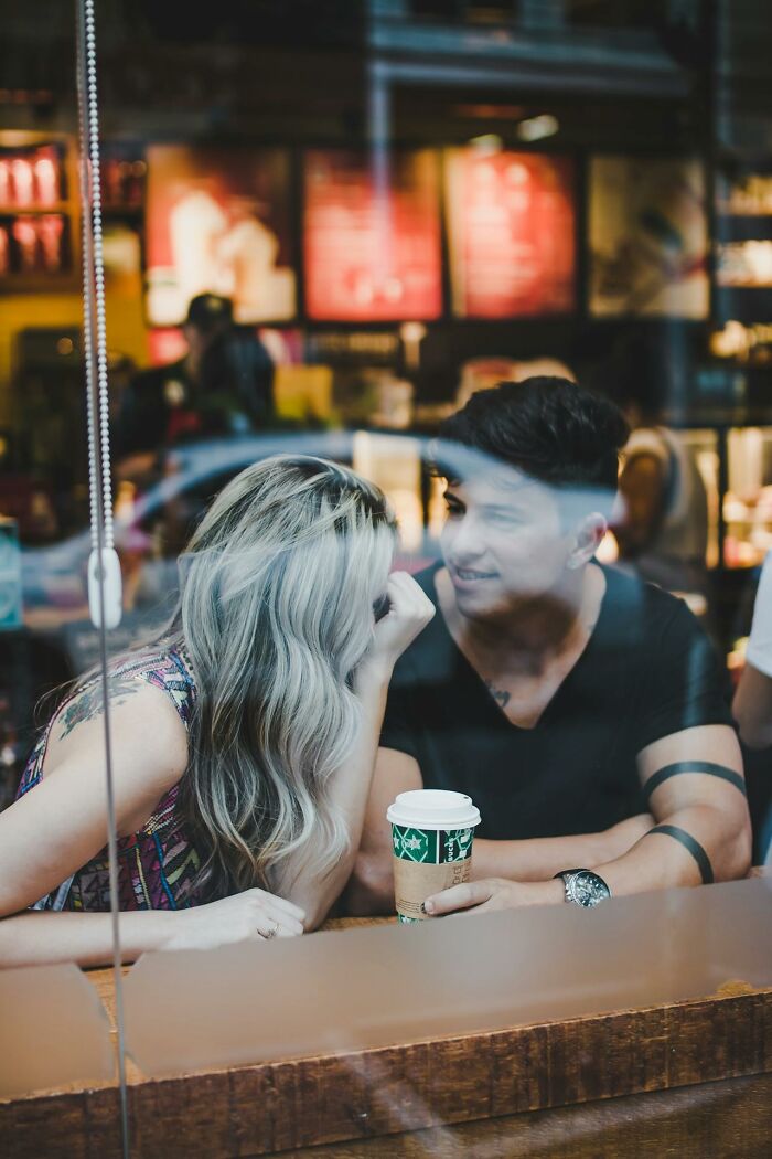 Man and woman sharing a coffee shop moment, illustrating non-sexual things men do that attract women.