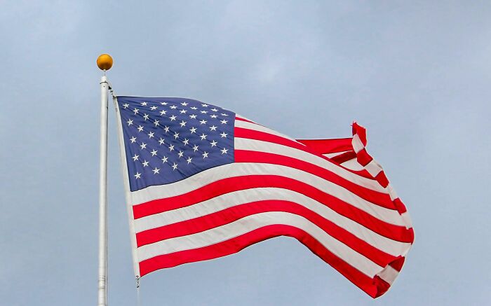 U.S. flag waving against a clear sky, symbolizing concepts people struggle to grasp.