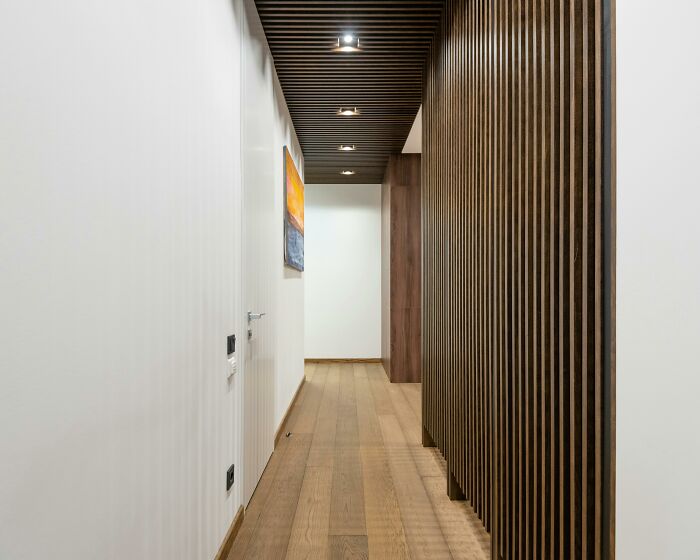 Modern hallway in a house with wooden slats and artwork.