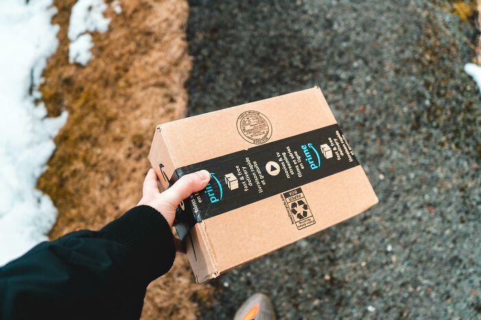 Hand holding a package outdoors.